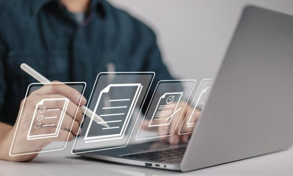 Persona trabajando en un portátil con documentos digitales