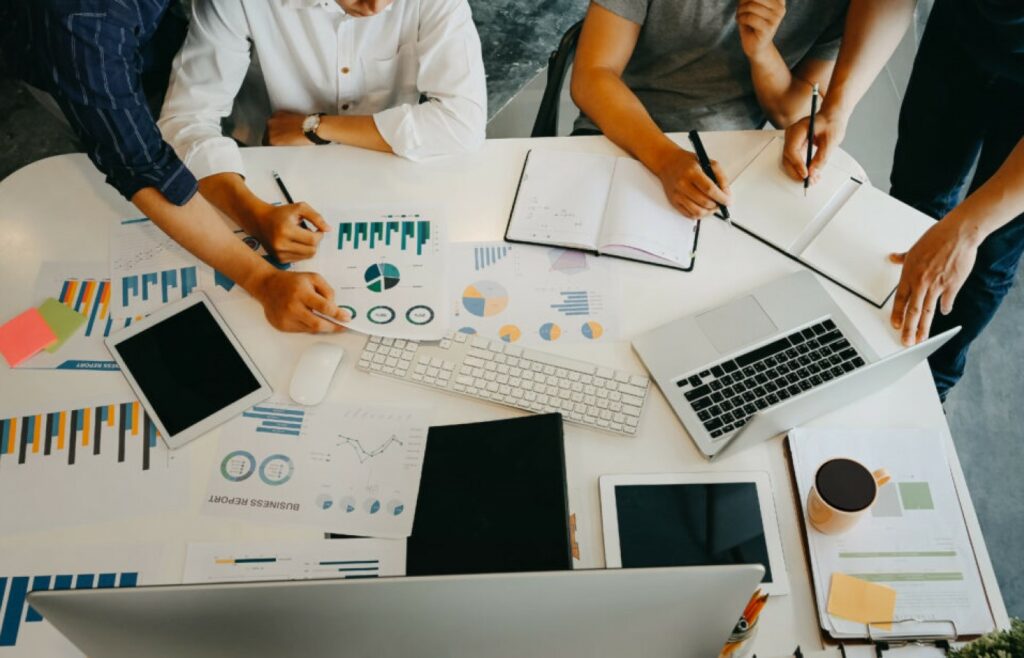 Equipo de trabajo revisando planes y gráficos sobre una mesa